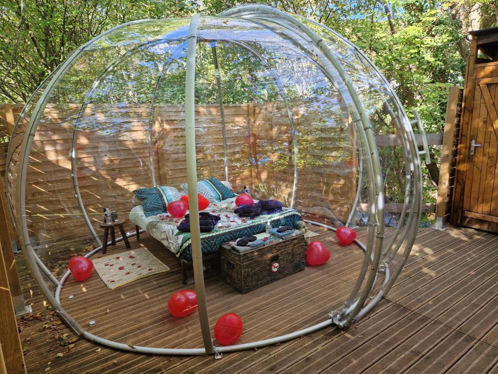 a gazebo with a couch in it on a deck at La Bulle du Cheix in Saint-Diéry