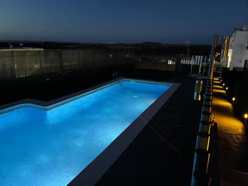 a swimming pool on the roof of a building at night at El Barro Colorao in Segura de León