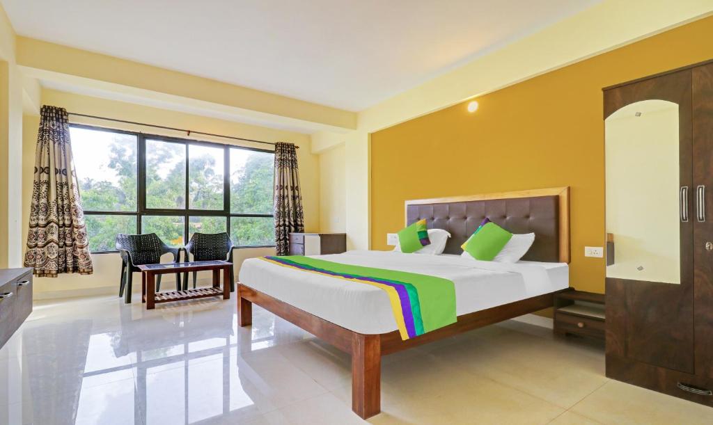 a bedroom with a large bed and a large window at Itsy By Treebo - Morjim Pride in Morjim