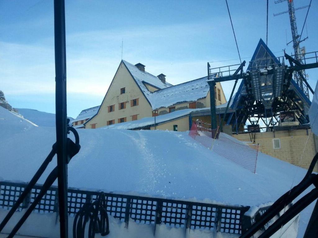 a snow covered roof of a building with a ski lift at Alberg Núria Xanascat in Queralbs