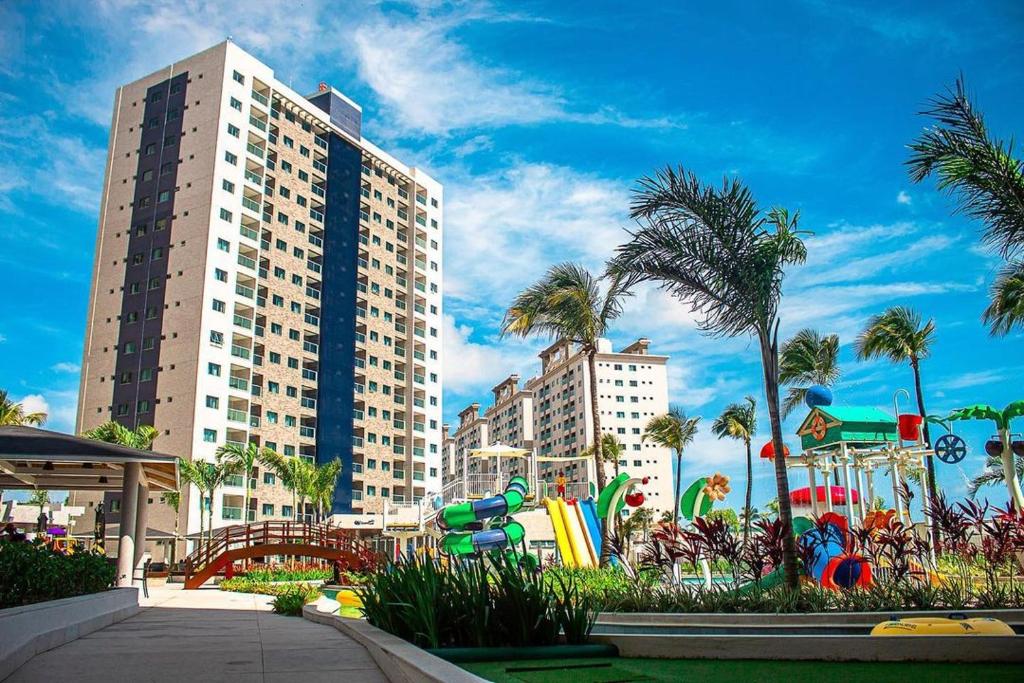 a playground in front of a large building with palm trees at Salinas Exclusive Resort in Salinópolis