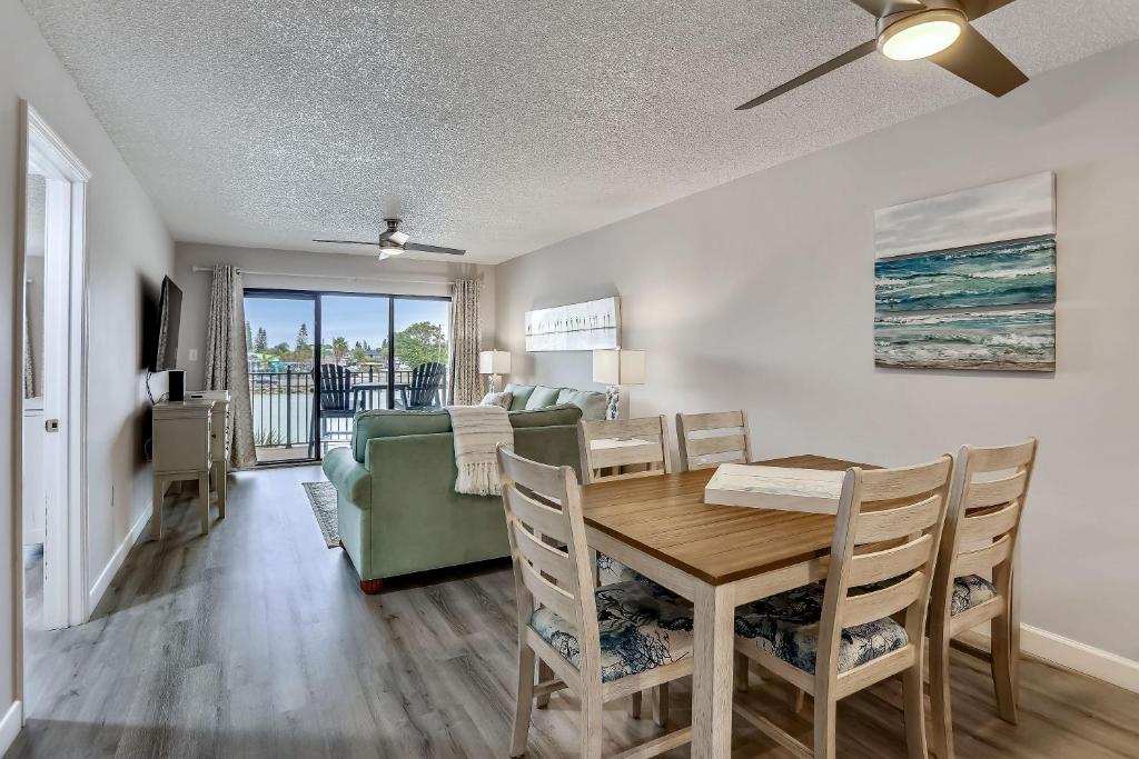 a dining room and living room with a table and a couch at Land's End 4-202 Bay Front - Premier in St. Pete Beach