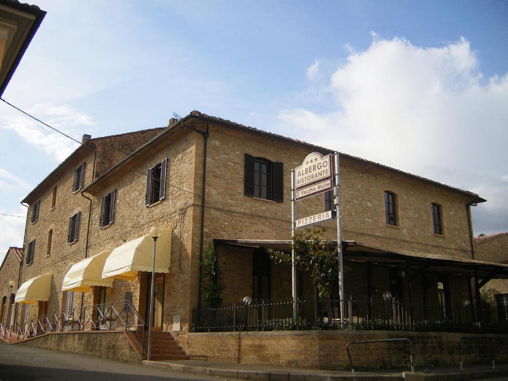 un edificio di mattoni con un cartello di fronte di Il Vecchio Mulino a Volterra