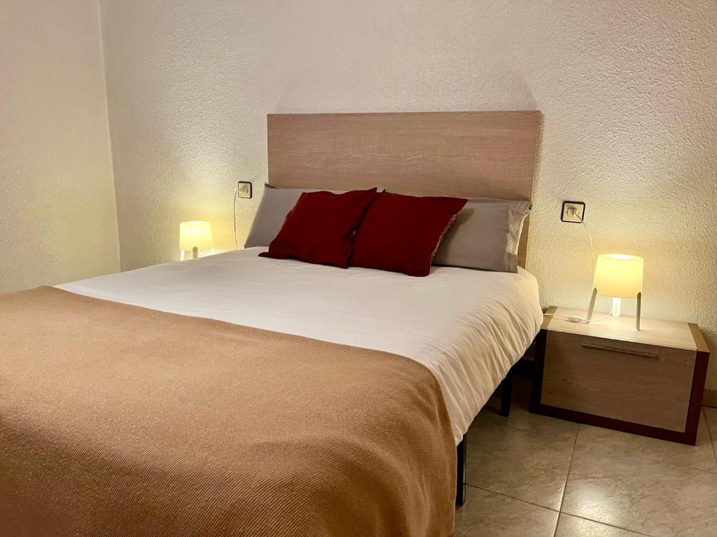 een slaapkamer met een groot bed met rode kussens bij Piso con encanto in Cehegín