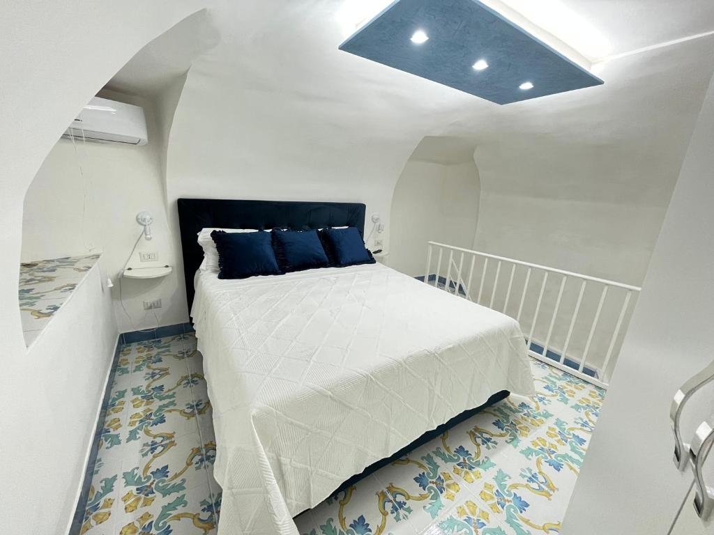 um quarto com uma grande cama branca com almofadas azuis em Domus Myosotis Apartment Napoli em Nápoles