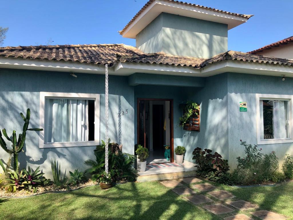 une maison bleue avec des plantes devant elle dans l'établissement Casa Azul, Long Beach Unamar Cabo Frio, à Tamoios