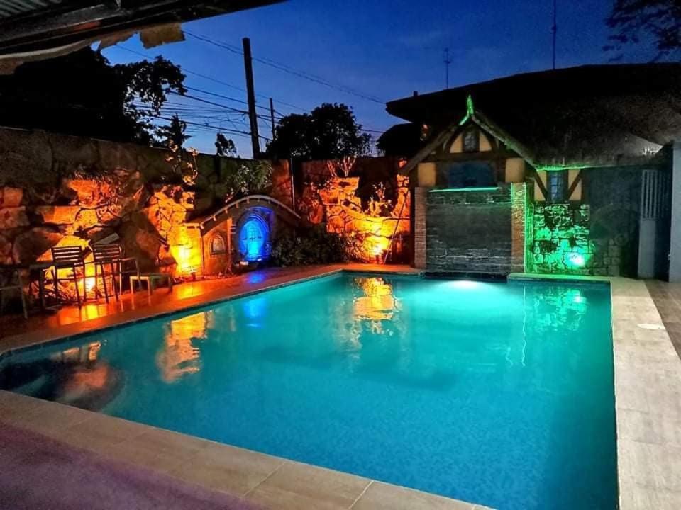 uma piscina com luzes num quintal à noite em The Shire Private Resort em Bago
