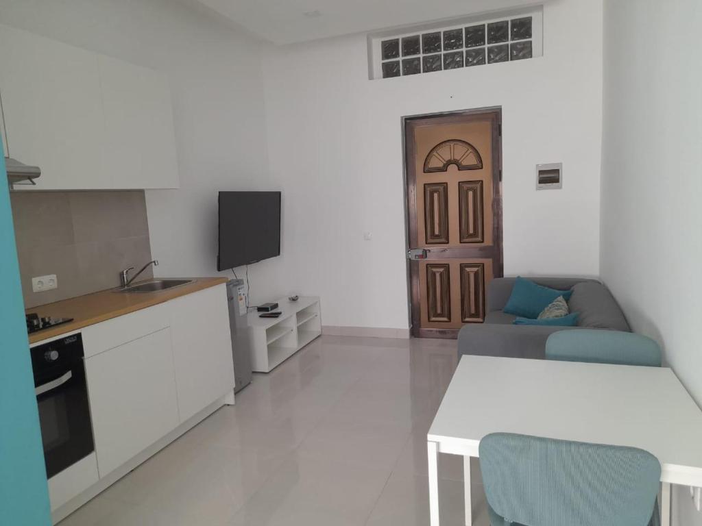 a kitchen and living room with a couch and a table at Apartamentos Morabeza in Mindelo