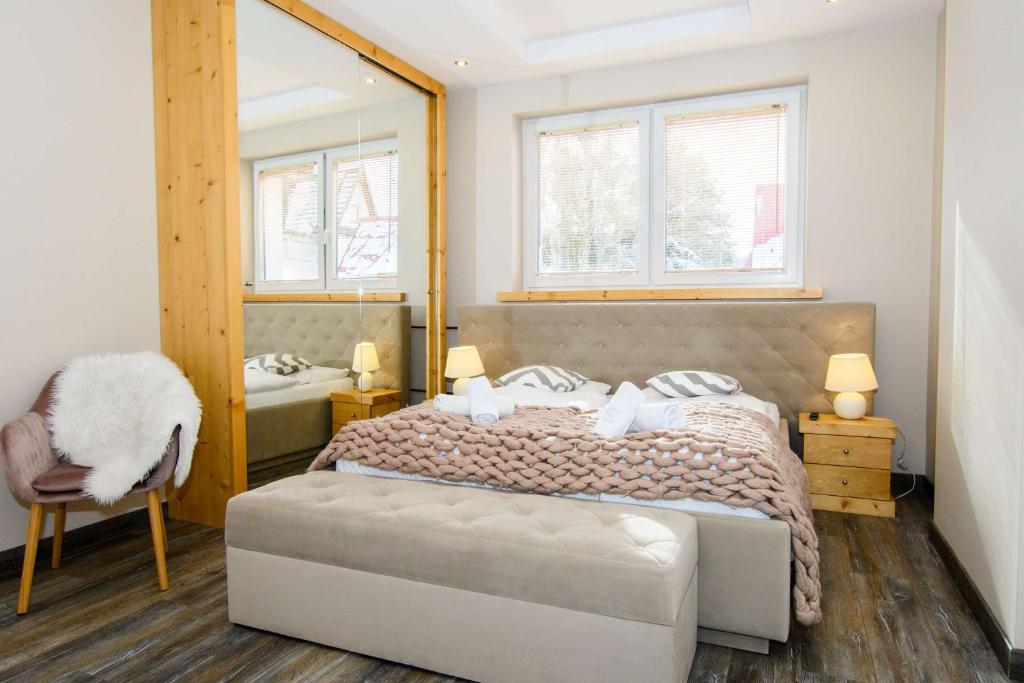 a bedroom with a large bed and a mirror at Apartamenty Siuster z widokiem na góry - doskonała lokalizacja, niedaleko Term Bukovina in Bukowina Tatrzańska