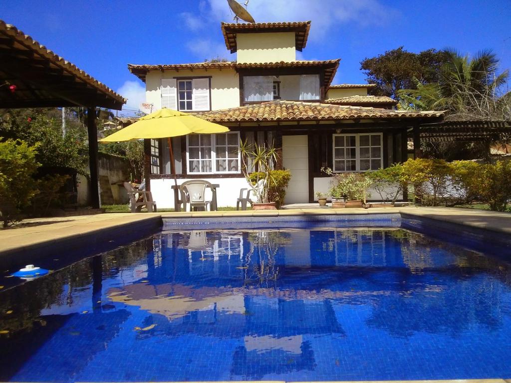 a house with a swimming pool in front of a house at Residence Solemare in Búzios