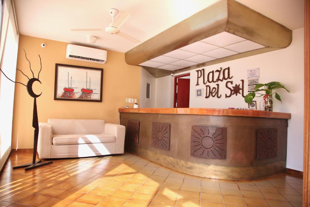 un vestíbulo con una zona de espera con una silla blanca en Aparta Hotel Plaza del Sol en Santo Domingo