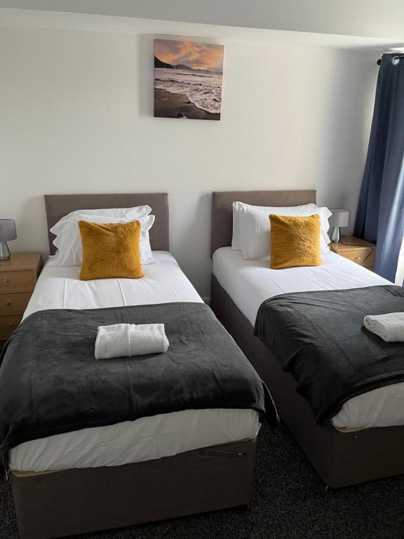 1 dormitorio con 2 camas con almohadas amarillas en Wymington House en Bedford