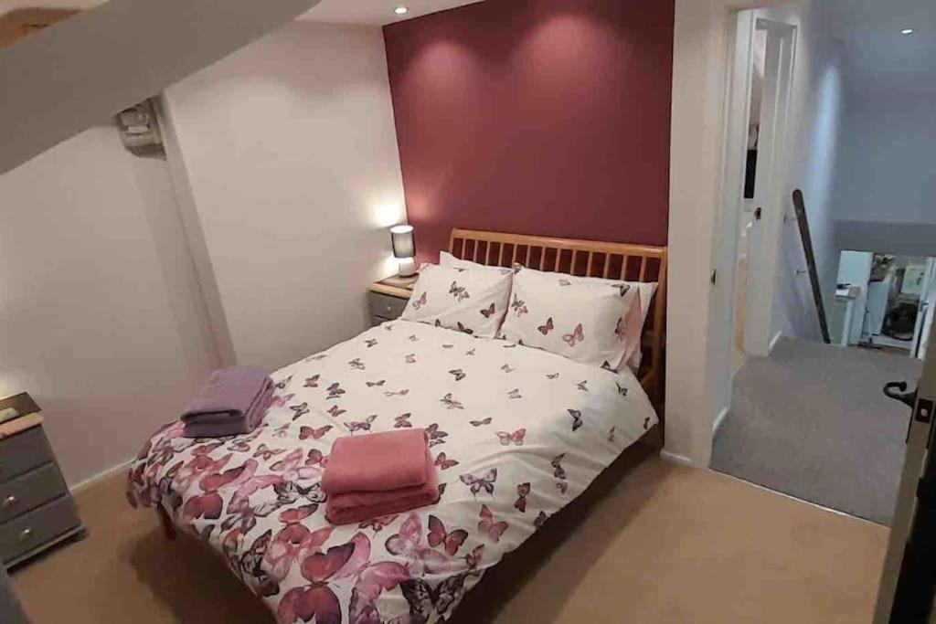Schlafzimmer mit einem Bett mit rosa und weißer Bettwäsche in der Unterkunft Willow Cottage Cosy Cornish Rural Retreat - Dog Friendly Cornwall in Ponsanooth