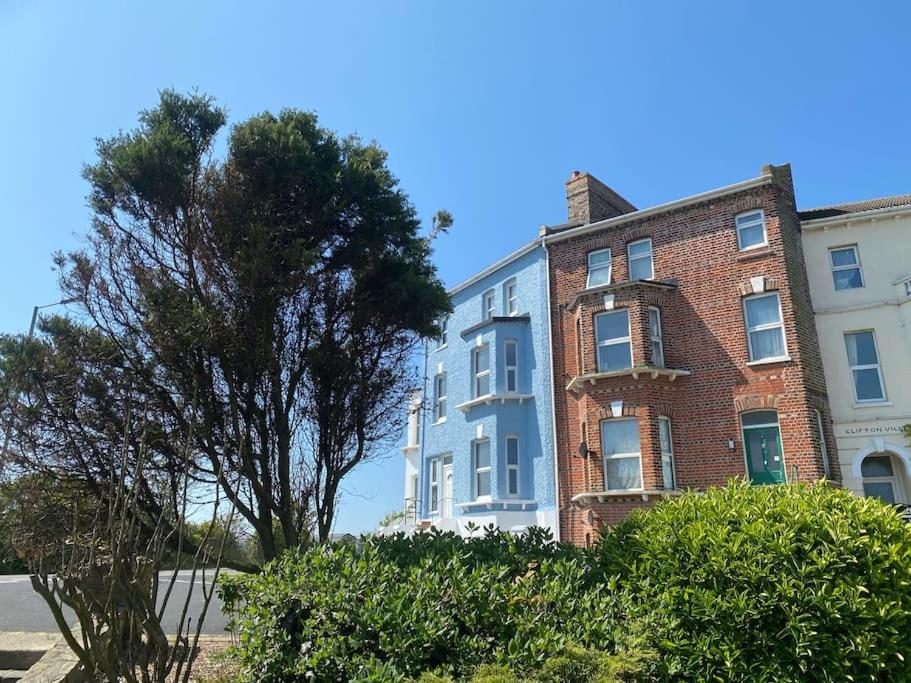 un grande edificio in mattoni con un albero di fronte di Lovely 1 bed flat 200 metres from beach a Walton-on-the-Naze