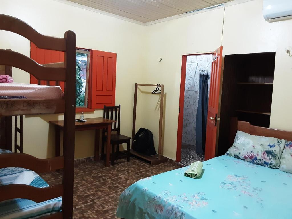 - une chambre avec un lit, un bureau et des lits superposés dans l'établissement Albergue Flor do Caribe, à Parintins