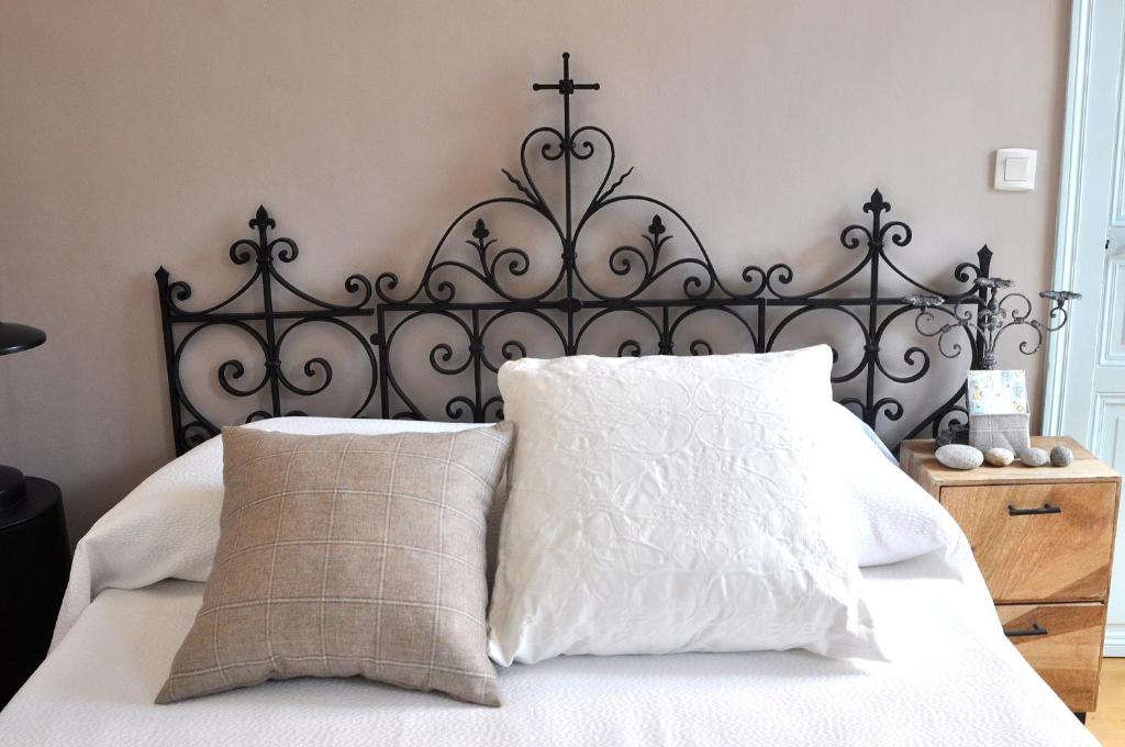a bed with a black headboard and two pillows at Bienvenue en terre écossaise in Aubigny-sur-Nère