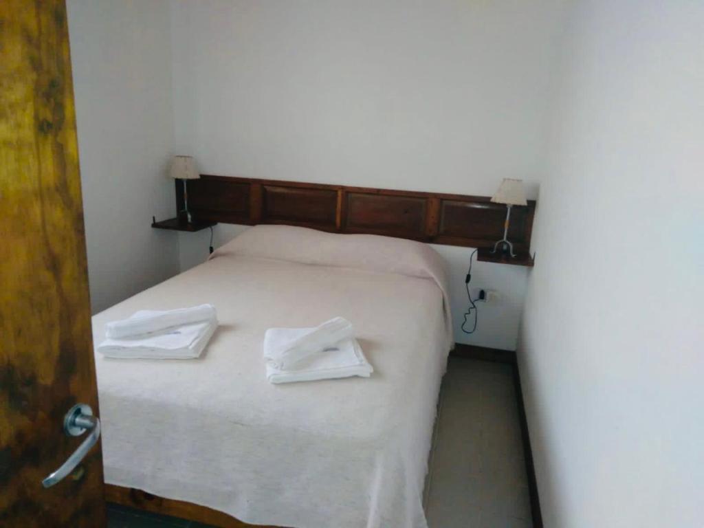 - une chambre avec un lit et 2 serviettes blanches dans l'établissement Primero de Abril, à Villa General Belgrano