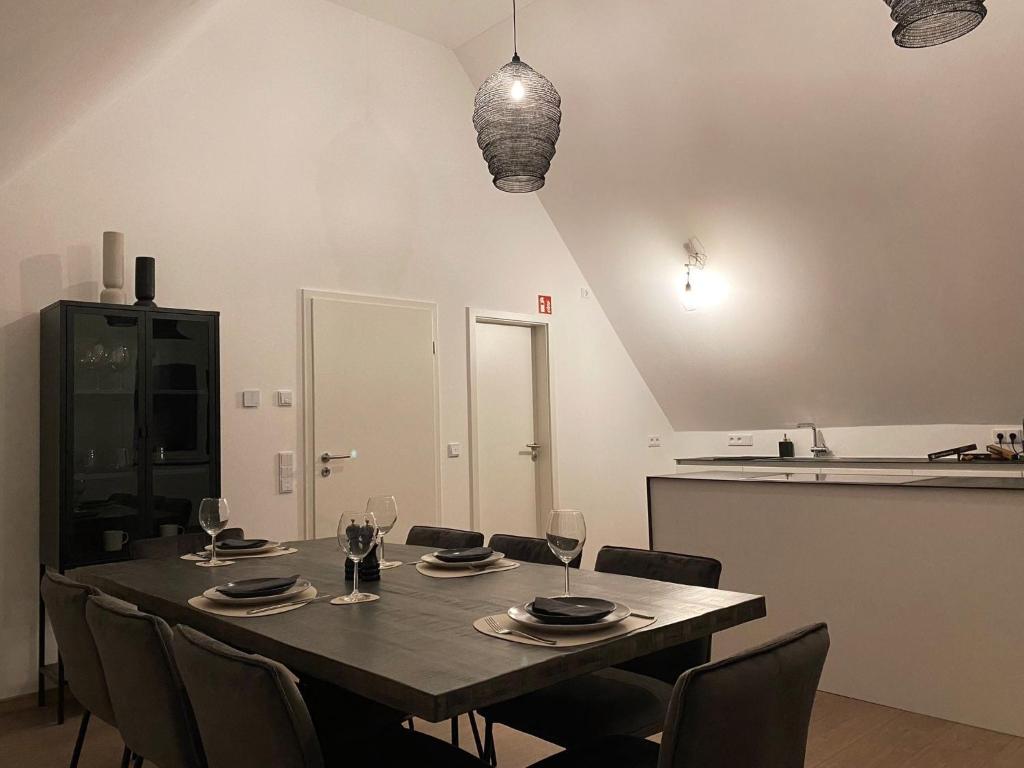 comedor con mesa y sillas con copas de vino en OASIS: Close to Munich - 4 Bedrooms - Kitchen, en Dachau
