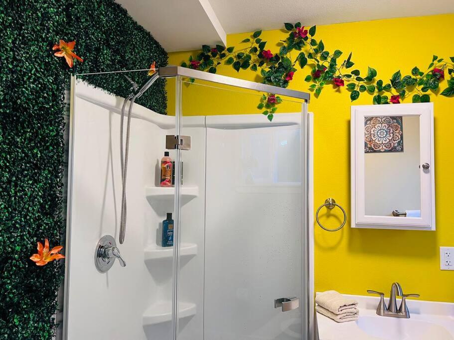 a bathroom with a shower and a sink and yellow wall at Talavera in Salem