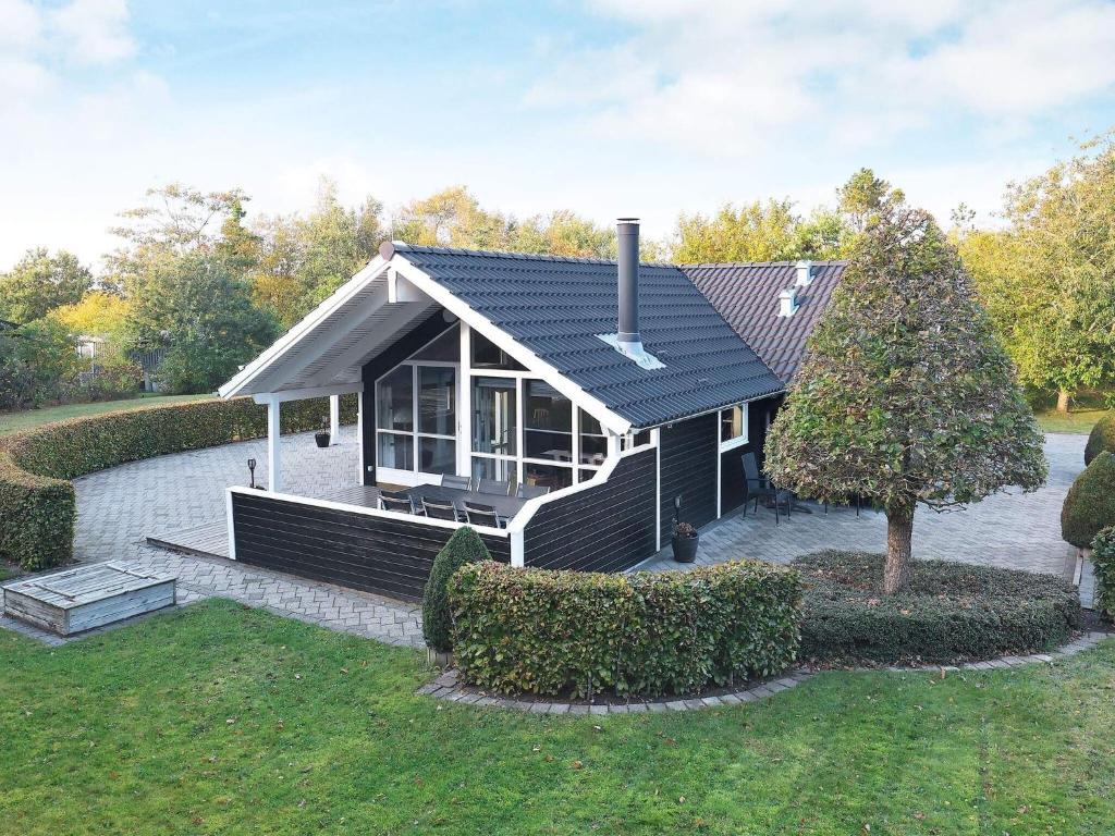 een klein huis met een zwart dak bij Holiday Home Marionsvej in Trend