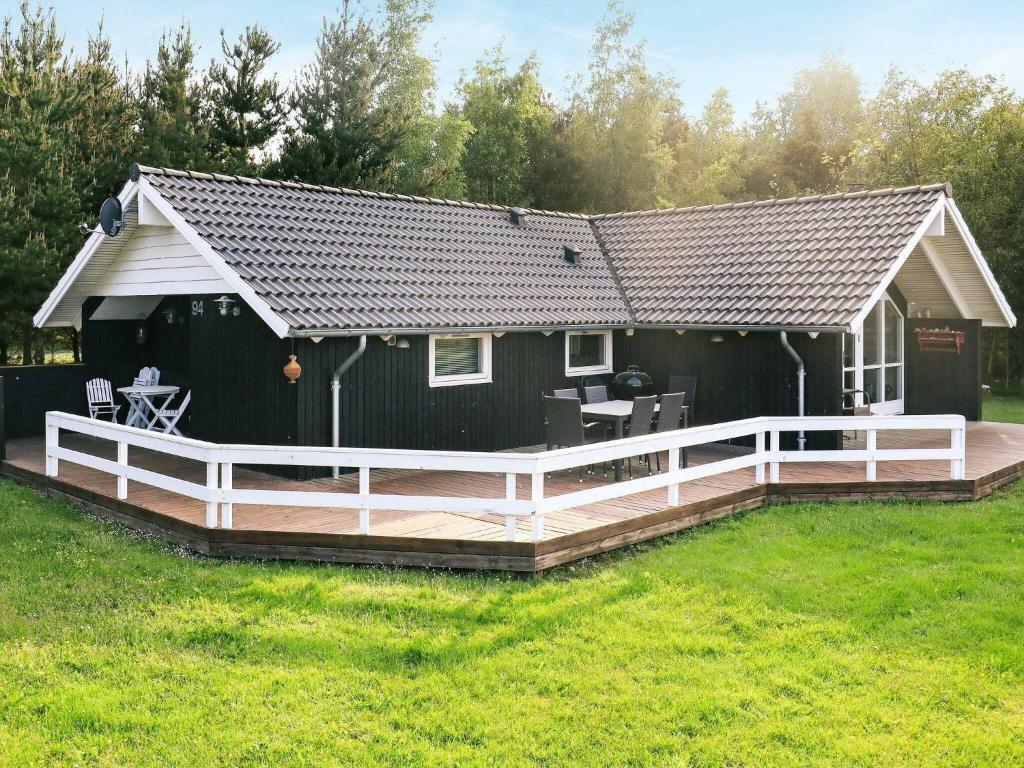 BøstrupにあるThree-Bedroom Holiday home in Højslev 4の木製デッキ付きの大きな黒い家