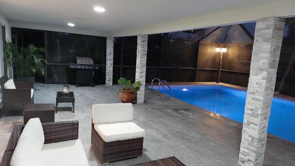 ein Wohnzimmer mit einem Pool in einem Haus in der Unterkunft Cape Coral Mini Palace in Cape Coral