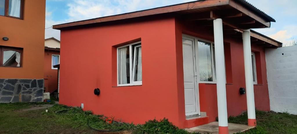 a red house with a white door at Lo de Kami in Ushuaia