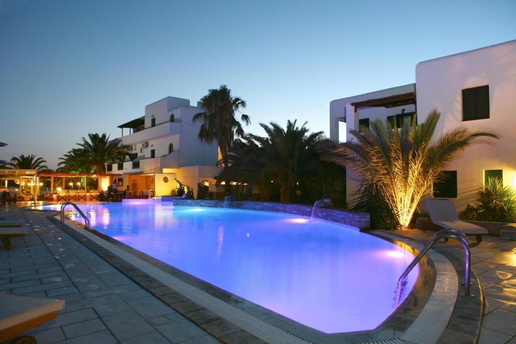 uma grande piscina com iluminação roxa em frente a um edifício em Corali Hotel Beach Front Property em Ios Chora
