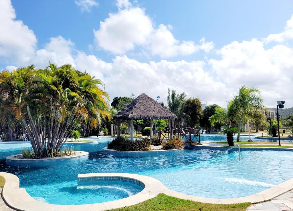 einen großen Pool mit Spielplatz und Palmen in der Unterkunft Iloa 3 quartos Luxo in Barra de São Miguel