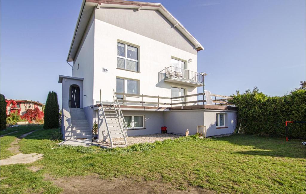 a white house with a staircase on the side of it at Stunning Apartment In Lubiatowo With Kitchen in Lubiatowo