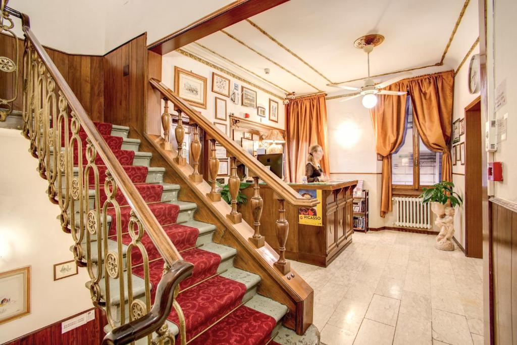 a staircase in a home with red carpeted stairs at Hotel Lorena in Florence