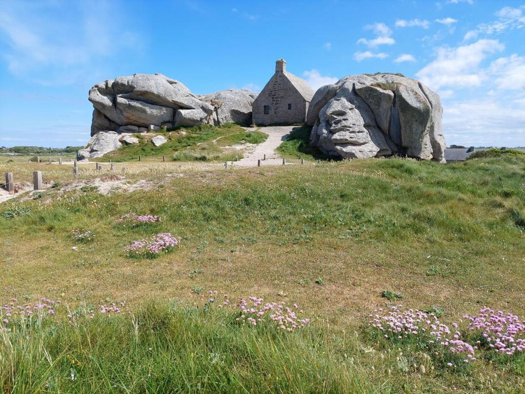 a house sitting on top of a hill with rocks at Holiday home with sea views, Plounéour-Brignogan-Plages in Plounéour-Trez