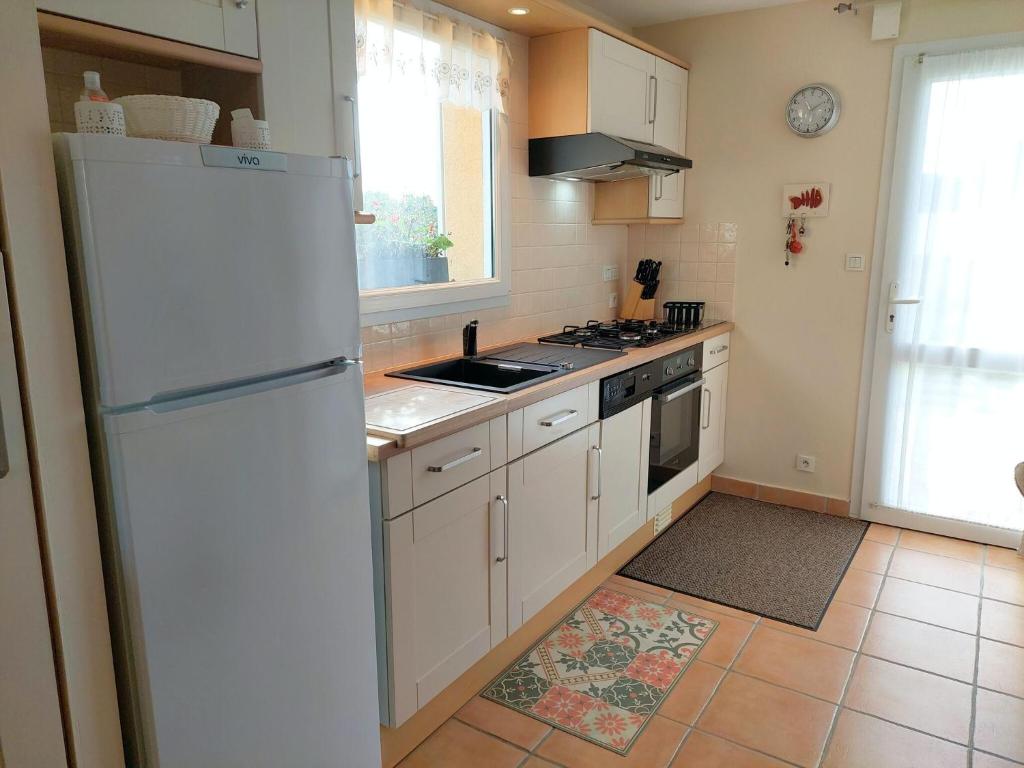 a kitchen with white cabinets and a white refrigerator at Holiday home with sea views, Plounéour-Brignogan-Plages in Plounéour-Trez