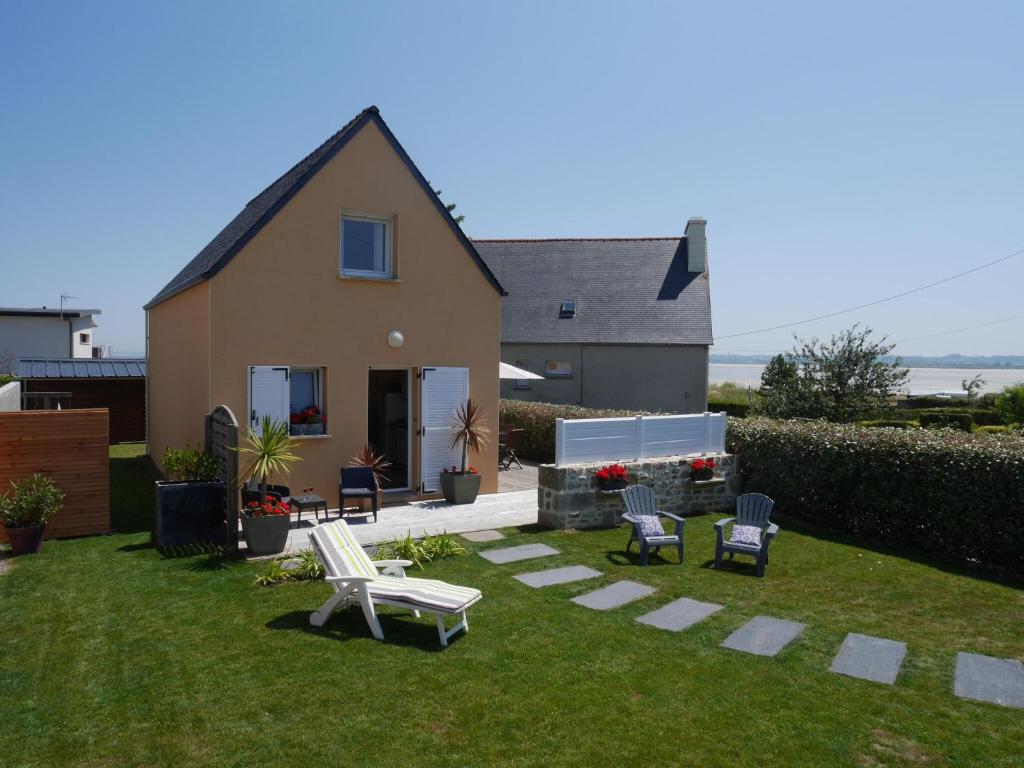 a yard with chairs and a house at Holiday home with sea views, Plounéour-Brignogan-Plages in Plounéour-Trez