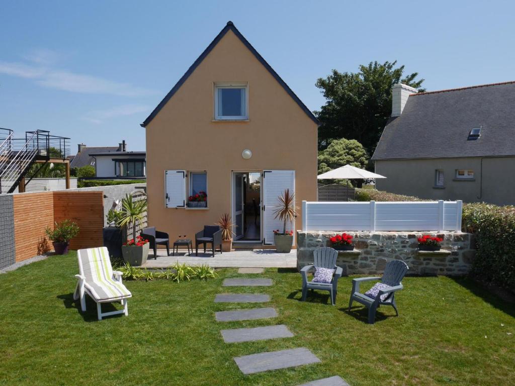 a yard with chairs and a house at Holiday home with sea views, Plounéour-Brignogan-Plages in Plounéour-Trez