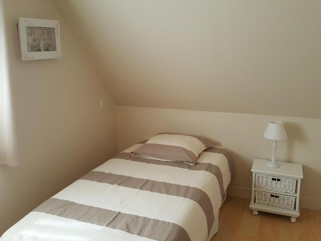 a small bedroom with two beds and a lamp at Holiday home with sea views, Plounéour-Brignogan-Plages in Plounéour-Trez
