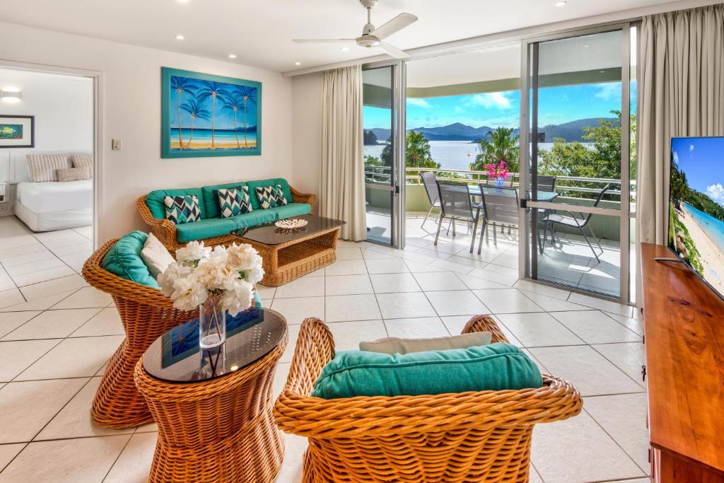 a living room with a couch and chairs at Lagoon Beachfront Lodge 107 on Hamilton Island by HamoRent in Hamilton Island