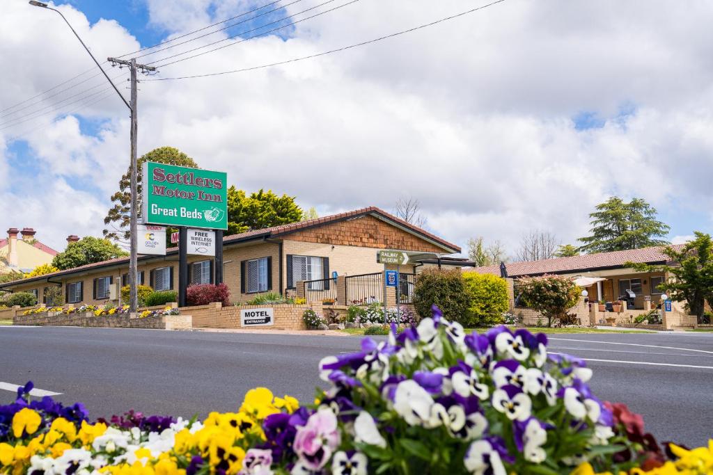 a street sign with flowers on the side of a road at Settlers Motor Inn in Tenterfield