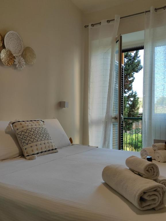 Un dormitorio con una cama blanca con toallas. en Domus Cese en Agrigento