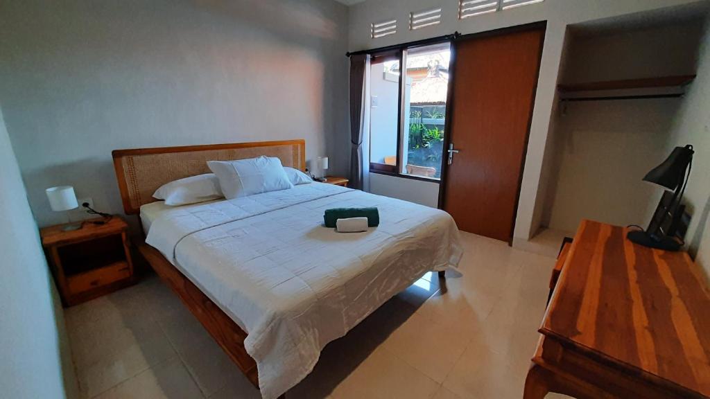 沙努爾的住宿－Agung's Annex Homestay，一间卧室配有一张大床,上面装有黑色钱包