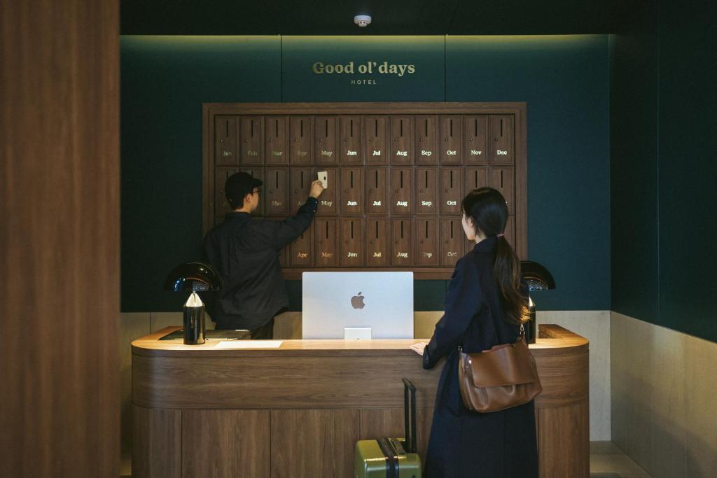 una mujer está parada en una caja registradora en Good Ol' Days Hotel en Busan