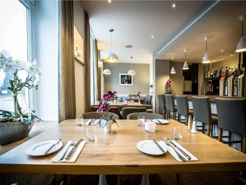 - une salle à manger avec une table et des chaises en bois dans l'établissement Hotel Haberkamp, à Achim