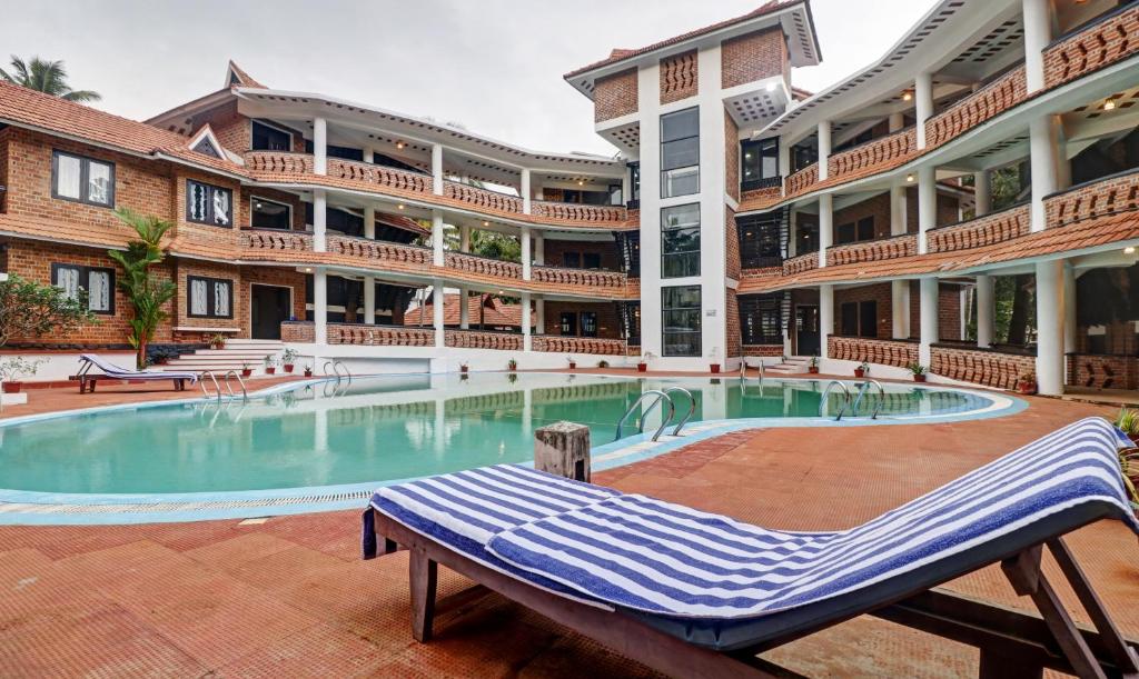 un gran edificio con piscina frente a un edificio en Treebo Trend God'S Own Country Ayurveda Resorts, en Kovalam