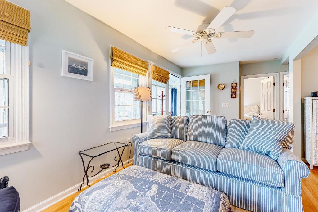 a living room with a blue couch and a ceiling fan at Town of Rehoboth Beach - 50A Olive Ave in Rehoboth Beach