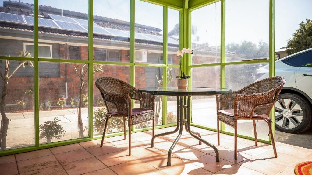 una mesa de cristal y sillas en una habitación con ventana en Sunshine Retreat Villa 4, en Cowes
