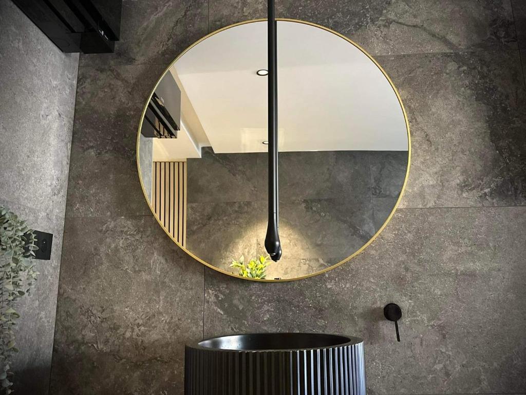 łazienka z okrągłym lustrem na ścianie w obiekcie L’ODYSSÉE SPA w mieście Seclin