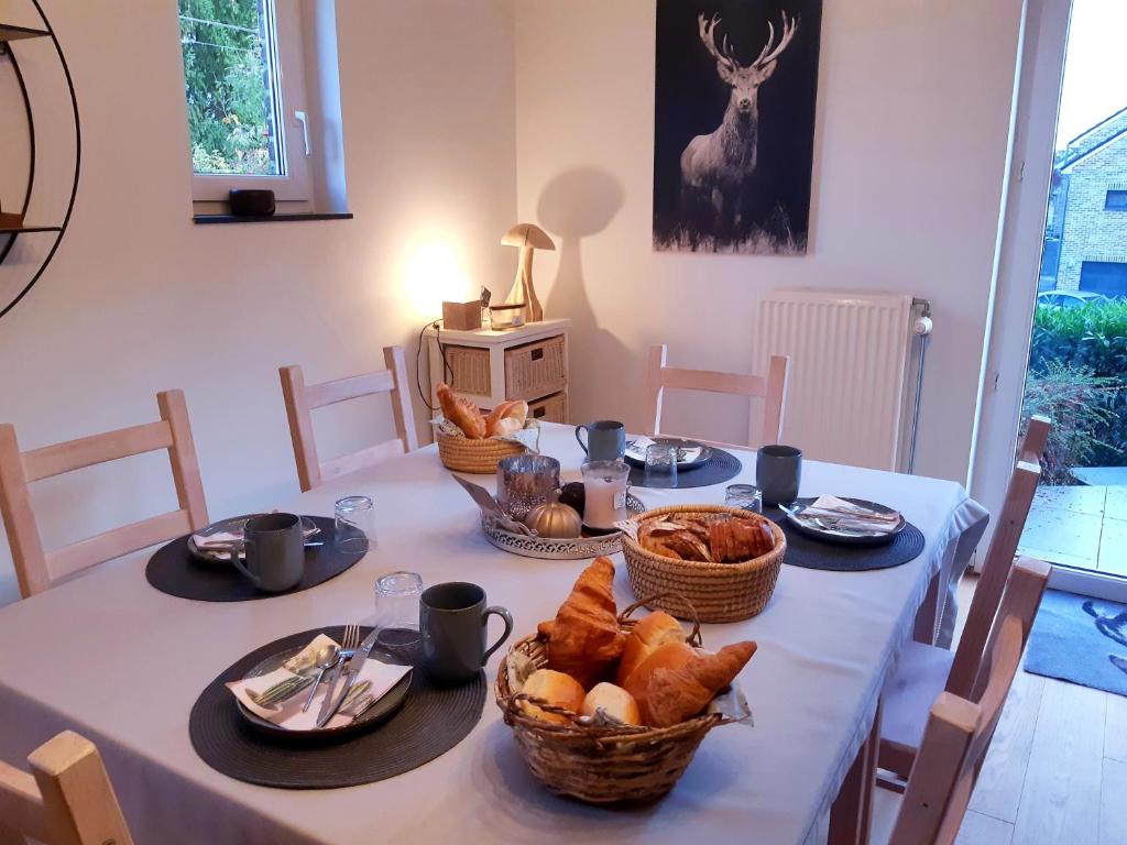 a table with bread and baskets of food on it at B&B Caprice d'Epices in Francorchamps