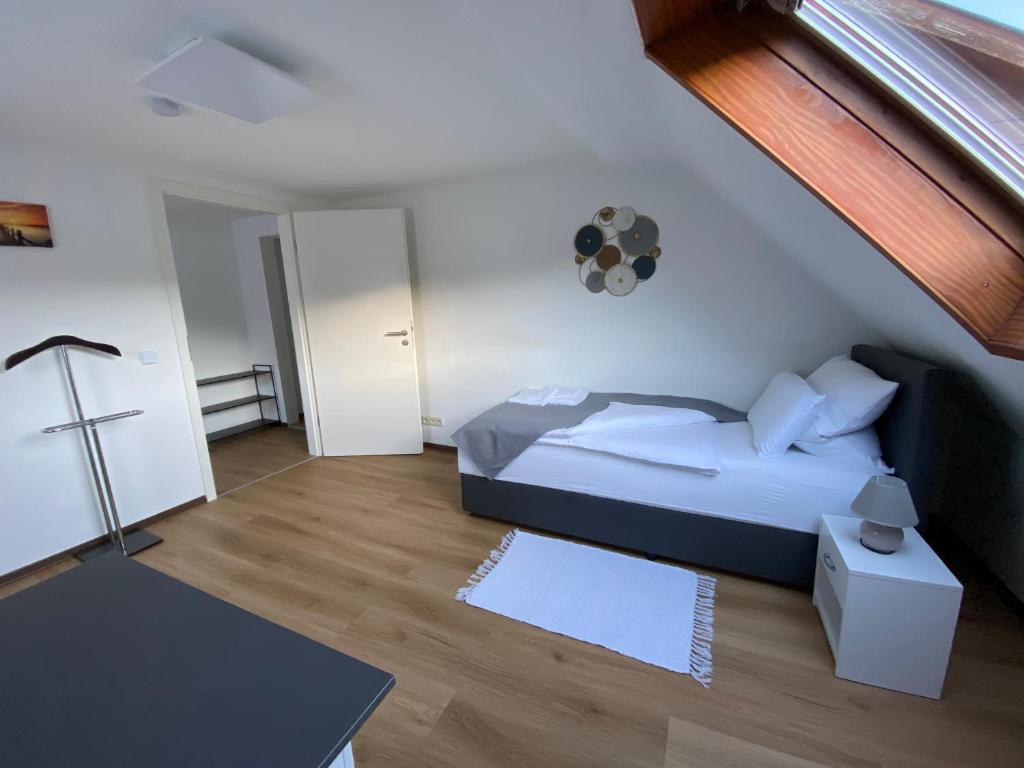 Apartment Q im Zentrum von Königsbronn في Königsbronn: غرفة نوم بسرير وصالب على الحائط