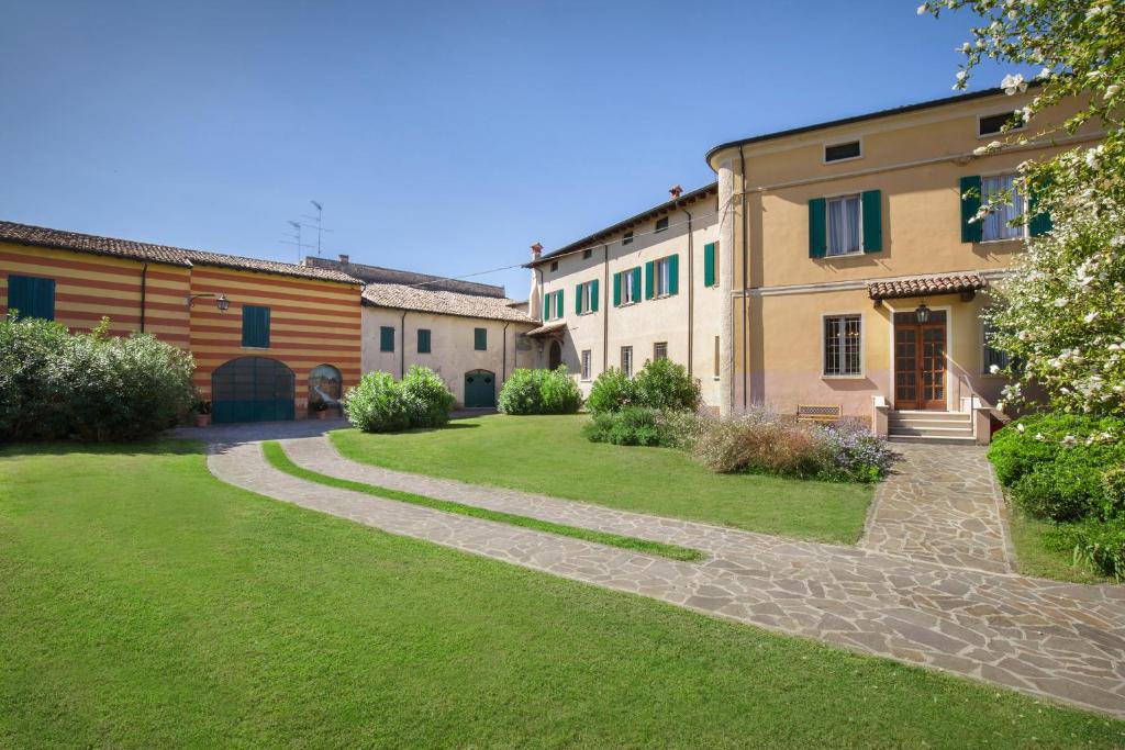 a courtyard of a building with a grass yard at Villa Oleandra with Pool up to 12 People in Volta Mantovana
