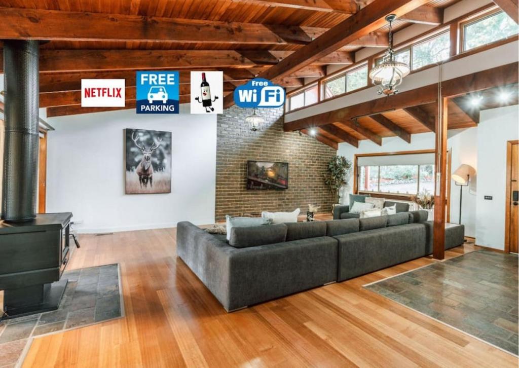 a living room with a couch and a brick wall at Olinda Nature Retreat 4 Bed 3Bth House Fire, Bath in Olinda